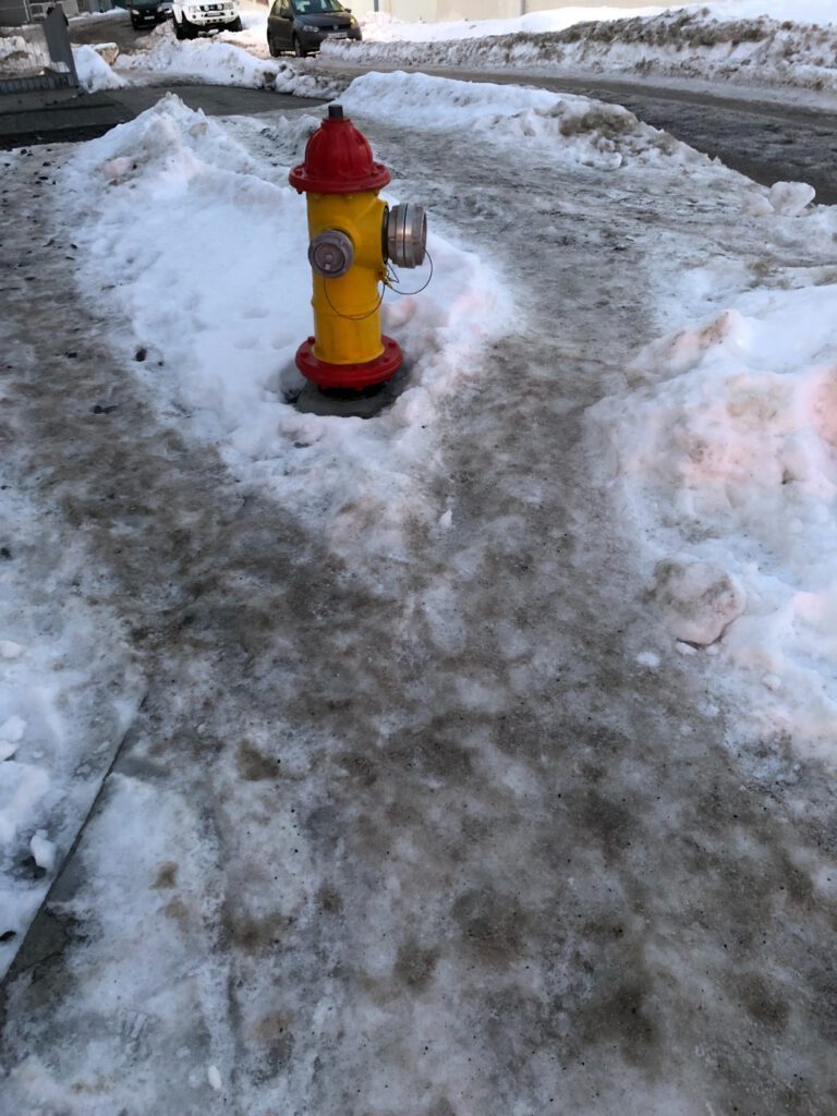 vereister Bürgersteig mit Hydranten in Reykjavik