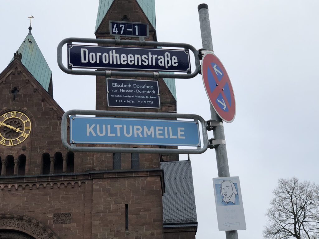 Das Straßenschild Kulturmeile Dorotheenstraße in Bad Homburg, Teil des Hölderlinswegs. Im Hintergrund die Erlöserkirche