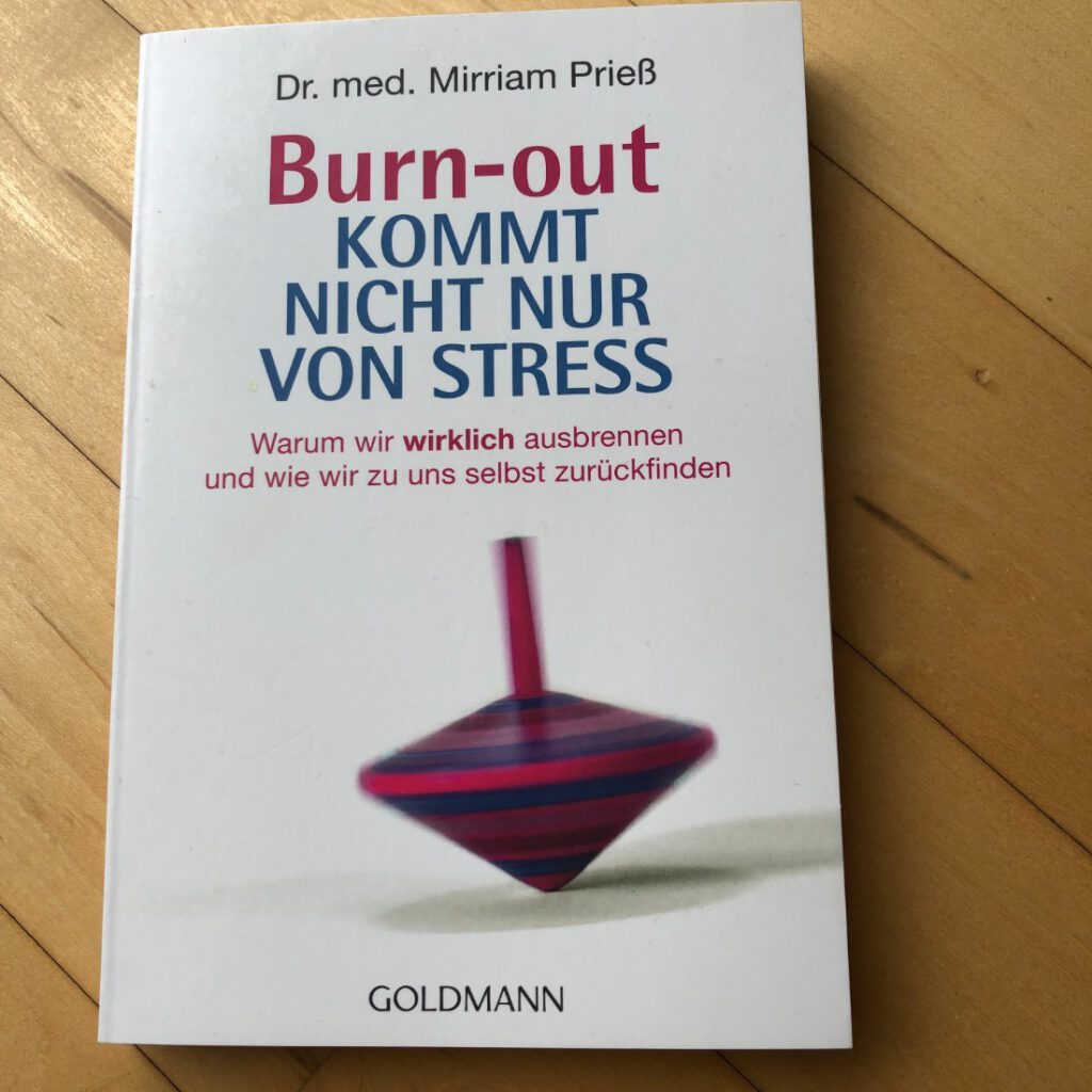 berufliche Lektüre: "Burn-out kommt nicht nur von Stress" von Dr. med. Mirriam Prieß mit einem unscharfen, sich drehenden Kreisel auf dem Cover