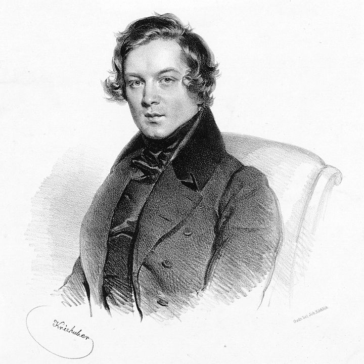 Schwarz-weiß Zeichnung des Portraits Robert Schumanns von Krishuber aus dem Jahre 1839. Er sitzt in einem Lehnstuhl ud schaut den Betrachter mit ernstem Gesichtsausdruck an. Gekleidet ist er in einen Mantel oder einer Jacke mit hohem Kragen und einem Bekleidungsstück, dass bis zum Kinn reicht.
